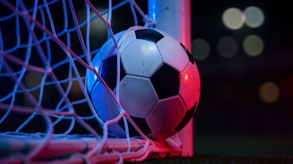 Minge de fotbal prinsă în plasa porții, luminată în roșu și albastru, pentru articolul despre PSG - Barcelona 4-2.